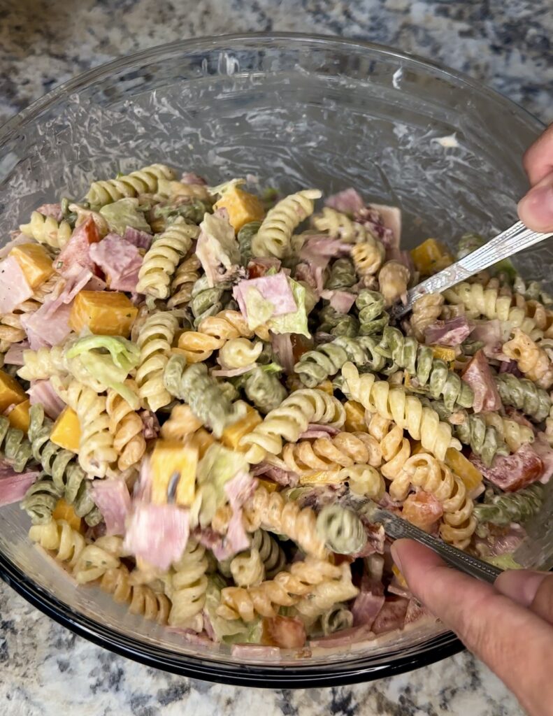 tossing the pasta salad