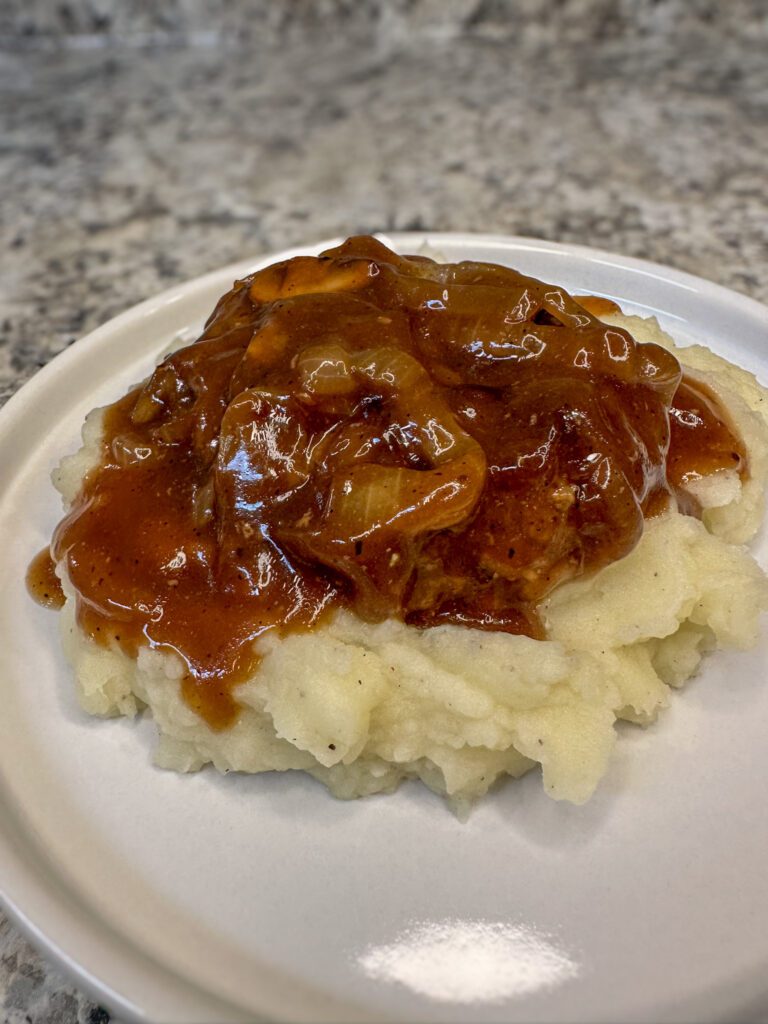 hamburger steaks over mashed potatoes